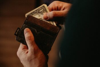 Someone taking a dollar out of a wallet.